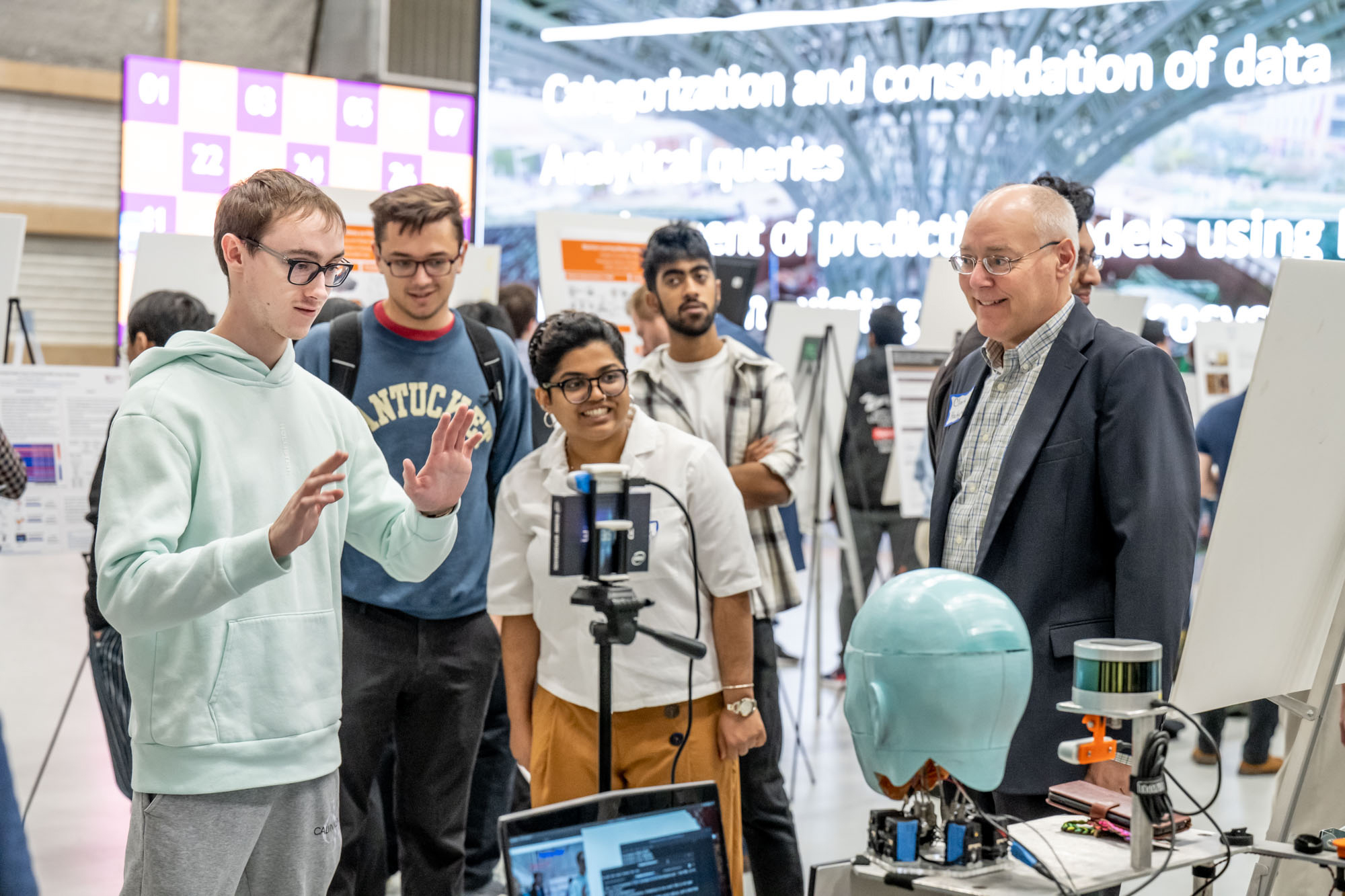 'Students stand around an AI booth at a symposium'